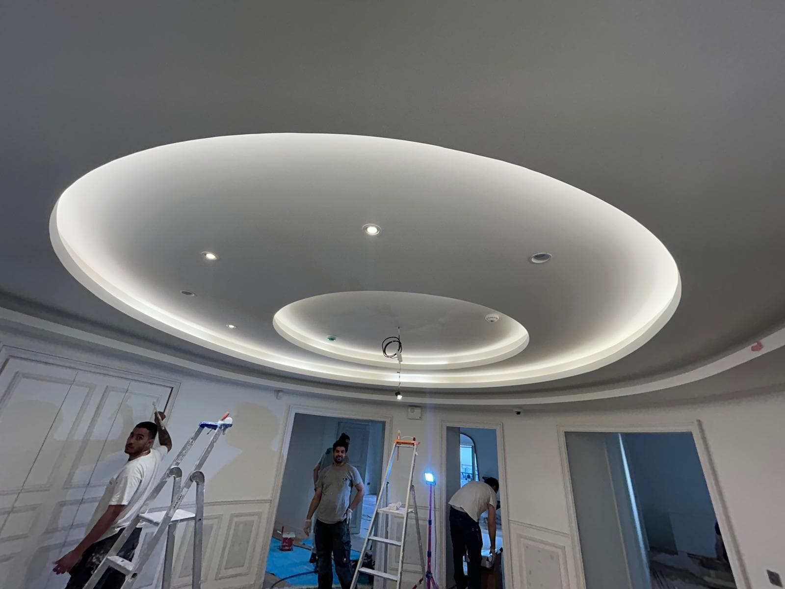 Artisans en finition d’un faux plafond circulaire à éclairage indirect